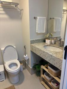 a bathroom with a toilet and a sink at Loft Boa Viagem - Uni Studios in Niterói