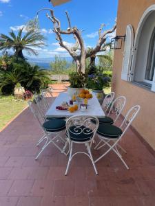 een tafel en stoelen op een terras bij Un Paradiso a Sorrento con piscina in Massa Lubrense