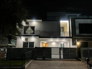 a large white building with a balcony at night at Family Cottage Islamabad in Islamabad