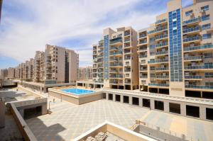 Una vista desde la azotea de un edificio con piscina. en أبراج الداون التاون سيتي ايدج العالمين الجديده, en Dawwār Abū Maḩrūs