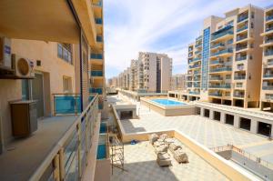 Apartamento con balcón con piscina y edificios en أبراج الداون التاون سيتي ايدج العالمين الجديده, en Dawwār Abū Maḩrūs