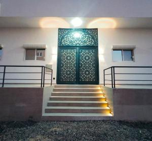 a green door on the side of a building with stairs at Arabic Apartment in Safaga