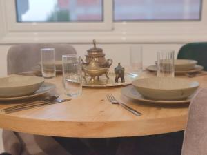 a wooden table with plates and bowls and glasses at Arabic Apartment in Safaga
