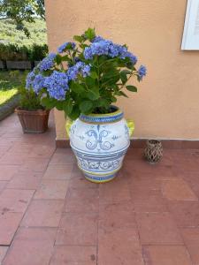 een blauw-witte vaas met blauwe bloemen erin bij Un Paradiso a Sorrento con piscina in Massa Lubrense
