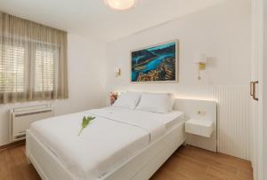 科托尔Apartments Los Olivos的白色的卧室设有一张大床和一个窗户