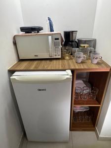 a microwave sitting on top of a counter at Suite Dunas do Peró in Cabo Frio
