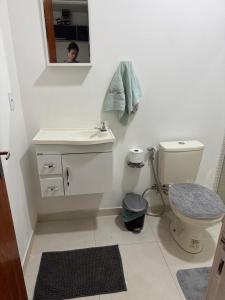 a bathroom with a toilet and a sink and a mirror at Suite Dunas do Peró in Cabo Frio +5 photos