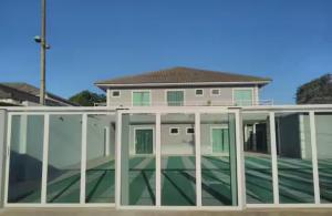 a house with a conservatory with glass doors at Suite Dunas do Peró in Cabo Frio