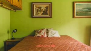 a green bedroom with a bed in a room at Sitio em Teresópolis com Piscina e Churrasqueira in Teresópolis