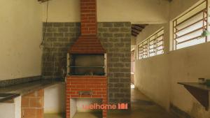 a brick oven in the middle of a room at Sitio em Teresópolis com Piscina e Churrasqueira in Teresópolis