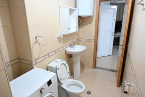 a small bathroom with a toilet and a sink at Vacation Apartments - Shengjin in Shëngjin