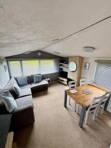 a living room with a couch and a table at Padstow Holiday Base Bright Two Bedroom Lodge at Seven Bays in St Merryn