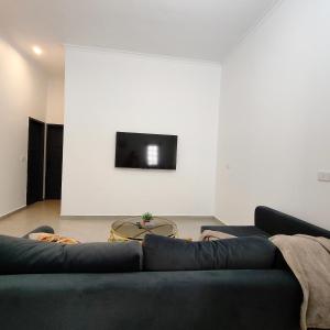a living room with a couch and a tv on a wall at Ocean Apartment in Safaga +21 photos