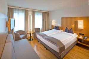een slaapkamer met een groot bed in een hotelkamer bij Hotel Maximilian - Stadthaus Penz in Innsbruck