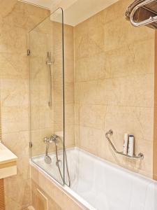 a bathroom with a tub and a glass shower at Garsoniera Rin Grand in Bucharest +10 photos