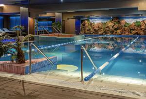 a large swimming pool in a hotel at Garsoniera Rin Grand in Bucharest