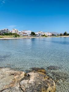 a view of a beach with rocks in the water at F K Apartments in Artemida