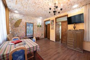 Un comedor con una mesa y un televisor en la pared. en ART Home Bobnevi, en Bobnevi