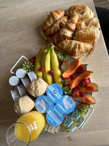 a tray of food with bread and fruit andositles at Au cocon des Corbière - La bohème in Lézignan-Corbières