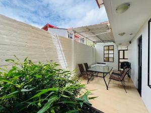 a patio with a table and chairs and a fence at Mansion del Bosque with Jacuzzi 6 Bedroom 5 Bath in Baños