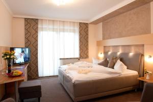 ロイパースドルフ・バイ・フュルステンフェルトにあるDreilandhofの大型ベッドとテレビが備わるホテルルームです。