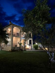a large white house with a yard at night at Poseidon Horizon in Leptokarya