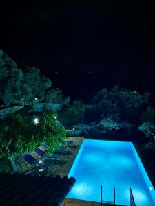 - une vue nocturne sur la piscine dans l'établissement Villa Melikokia, à Lygia