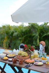 a table with plates of food and fruit on it at Vila Orun Pousada in Barreirinhas