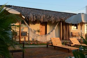 a house with a hammock outside of it at Vila Orun Pousada in Barreirinhas