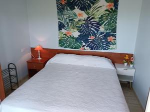 ein Schlafzimmer mit einem Bett und einem floralen Wandbild in der Unterkunft Ada Neptuno Apartamento, Aire acondicionado, WiFi, Piscinas, Parking in Peñíscola