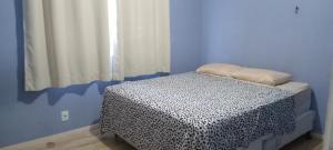 a blue room with a bed with a black and white blanket at Apartamento confortável a cinco minutos da praia de Icarai in Niterói +41 photos