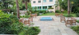 a patio with chairs and a pool in front of a building at Apartamento confortável a cinco minutos da praia de Icarai in Niterói