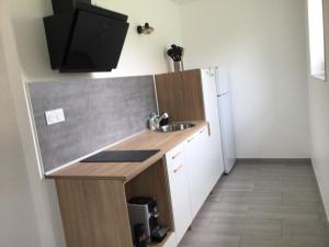 a small kitchen with a sink and a refrigerator at Maison à la campagne, proche de Guingamp in Ploumagoar +2 photos