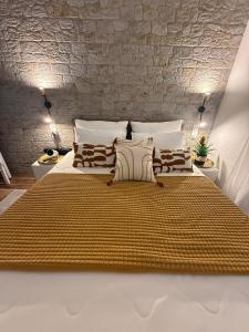 a large bed in a room with a stone wall at Diokletian's Golden Nest in Split