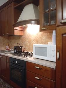 a kitchen with a stove and a microwave at La casa di Angel in Calangianus