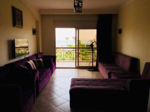 a living room with purple couches and a balcony at العين السخنة in Ain Sokhna