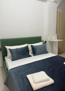 a large bed with blue pillows and a green headboard at Vila18 Vlore in Vlorë +43 photos