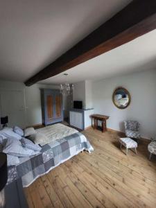 ein Schlafzimmer mit großem Bett und Holzboden in der Unterkunft Domaine de LOLI in Saint-Girons