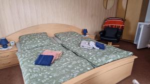 a bedroom with two beds and a chair at Pension Glück Auf in Brand-Erbisdorf