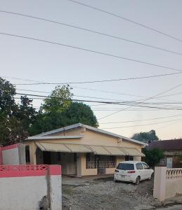 a white car parked in front of a building at Entire 3 bedroom house in St Thomas, Jamaica in Port Morant