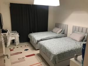 a bedroom with two beds and a table and a chair at Marassi marina 2 in El Alamein +27 photos
