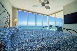 a bedroom with a bed with a view of the ocean at Luxurious 2BD Condo with Direct Ocean Front & Resort Pool in Sunny Isles in Sunny Isles +39 photos
