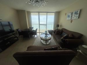 a living room with a couch and a table and a television at Luxurious 2BD Condo with Direct Ocean Front & Resort Pool in Sunny Isles in Sunny Isles