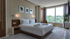 Un dormitorio con una cama grande con una ventana grande. en R&S Marina Bay Tanger Marsa, en Tánger