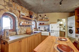 a kitchen with a wooden table and a stone wall at Casa Grotto in San Marcos