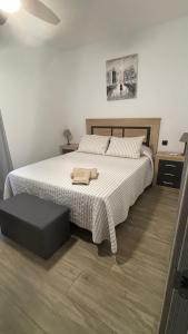 a bedroom with a large white bed with a ottoman at Casa Filo, maravilloso apartamento en Morro Jable in Morro del Jable