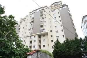a tall white building with trees in front of it at Beach Apartments - Shengjin in Shëngjin