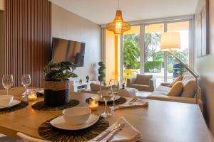 a living room with a wooden table with plates and wine glasses at Modern Ground Level Condo, 2 bedrooms, Direct pool access in Palm-Eagle Beach