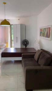 ein Wohnzimmer mit Sofa und Tisch in der Unterkunft Loft Reserva do Sahy - Mangaratiba in Mangaratiba