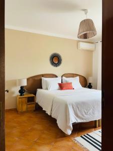 Schlafzimmer mit einem Bett mit weißer Bettwäsche und roten Kissen in der Unterkunft Olive Villa in Alcantarilha + 26 Fotos
